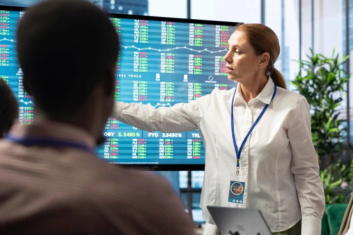 Ein vielfältiges Managementteam bewertet Budgetberichte an einem interaktiven Board.